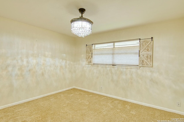 unfurnished room featuring carpet floors, baseboards, and an inviting chandelier