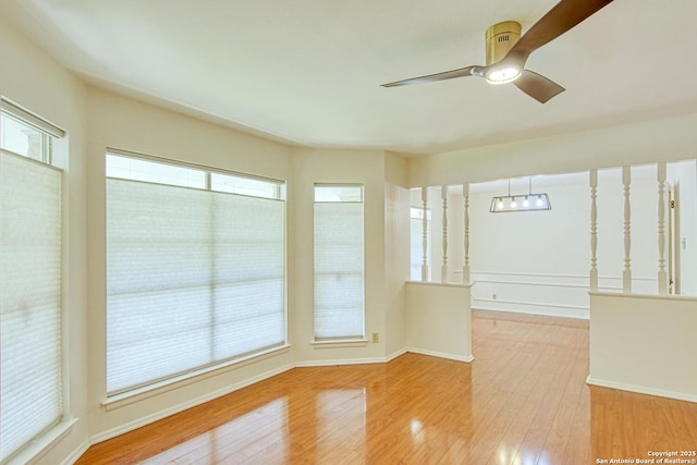 unfurnished room with ceiling fan, baseboards, and hardwood / wood-style flooring