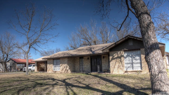 ranch-style house with a front yard and brick siding