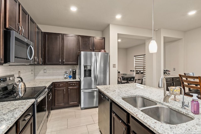 kitchen featuring recessed lighting, a sink, dark brown cabinets, appliances with stainless steel finishes, and backsplash