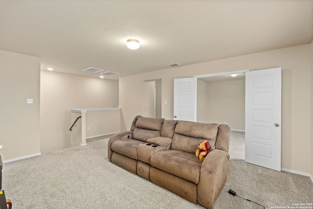 carpeted living room with a textured ceiling, visible vents, and baseboards