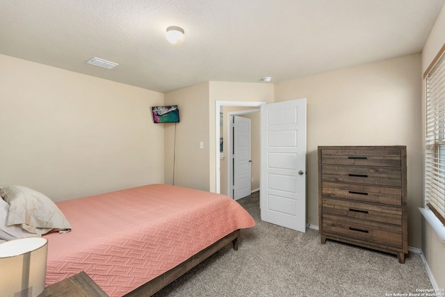 bedroom with carpet floors, visible vents, and baseboards