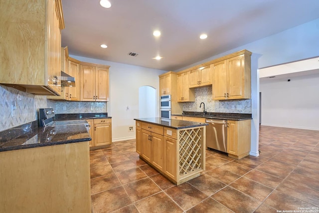 kitchen with arched walkways, appliances with stainless steel finishes, light brown cabinets, and visible vents