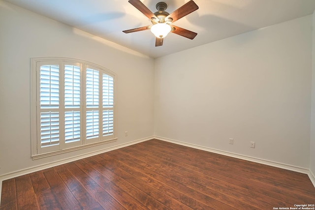 spare room featuring dark wood-style floors, baseboards, and a ceiling fan