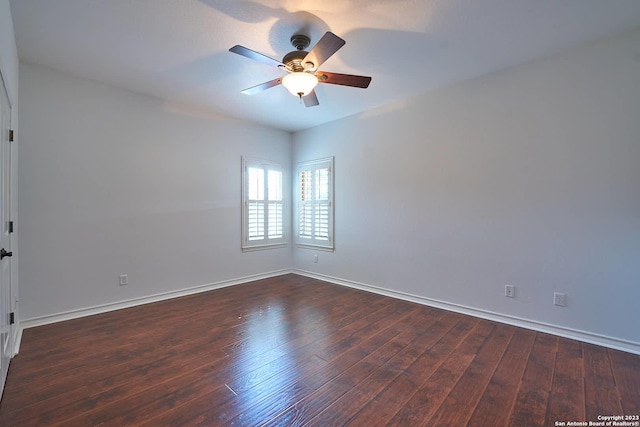 empty room with wood finished floors, a ceiling fan, and baseboards