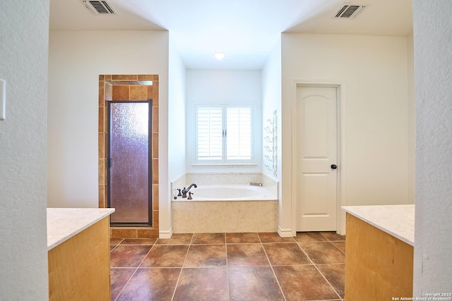 bathroom featuring a garden tub, vanity, a shower stall, and visible vents