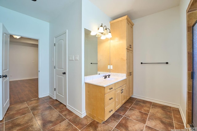 full bathroom featuring baseboards, a notable chandelier, and vanity