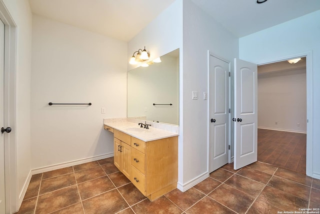 bathroom with tile patterned flooring, vanity, and baseboards