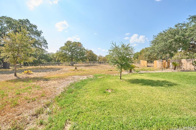 view of yard with fence and a rural view