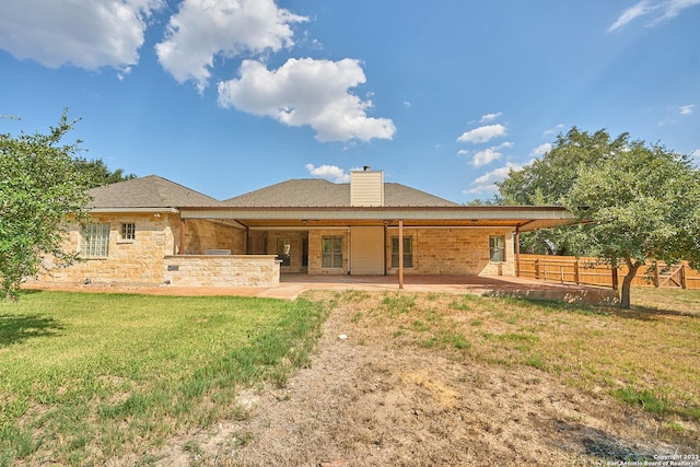 back of property featuring a patio area, a yard, a chimney, and fence