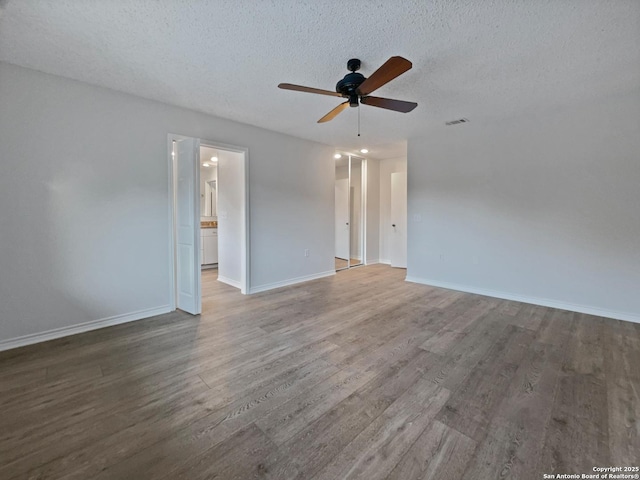 empty room featuring visible vents, ceiling fan, a textured ceiling, wood finished floors, and baseboards