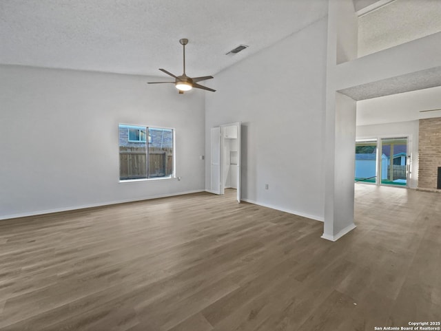 empty room with baseboards, visible vents, a ceiling fan, and wood finished floors