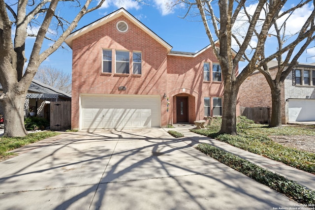 traditional-style home featuring concrete driveway, brick siding, an attached garage, and fence