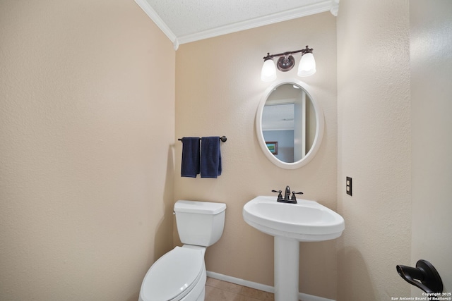 half bath with crown molding, toilet, a sink, tile patterned flooring, and baseboards