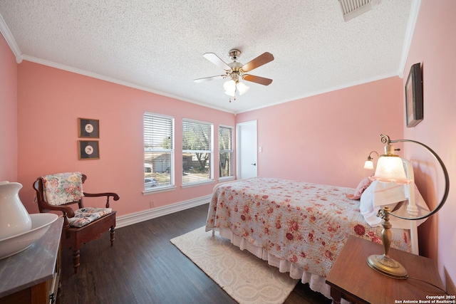 bedroom with baseboards, visible vents, dark wood-style floors, a textured ceiling, and crown molding