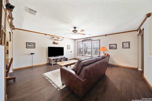 living area featuring visible vents, a textured ceiling, ornamental molding, and dark wood-style flooring