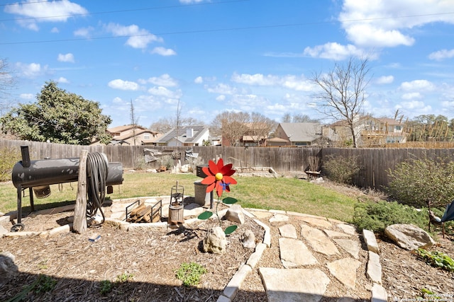 view of yard with a fire pit, a fenced backyard, and a residential view