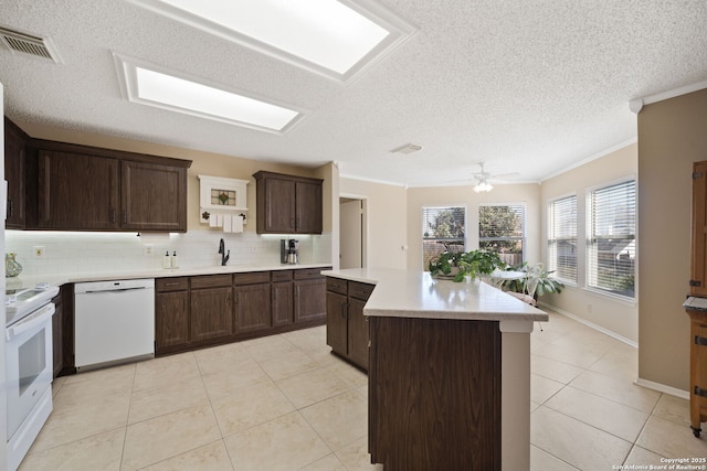 kitchen featuring white appliances, visible vents, light countertops, a center island, and tasteful backsplash