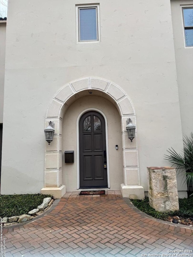 view of exterior entry with stucco siding