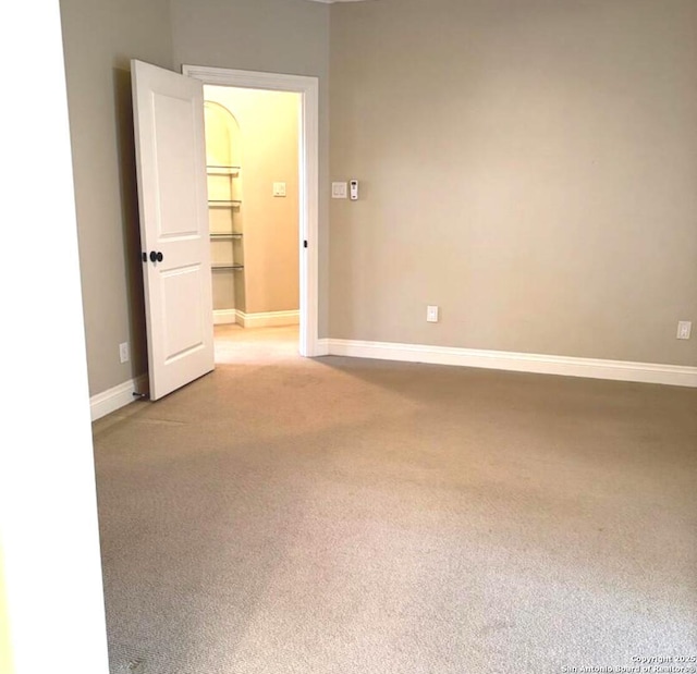 empty room with light carpet and baseboards