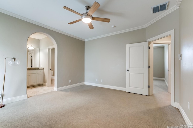 unfurnished bedroom with arched walkways, visible vents, crown molding, and light carpet