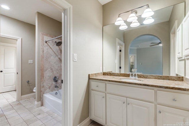 bathroom with toilet, ceiling fan, baseboards, and vanity