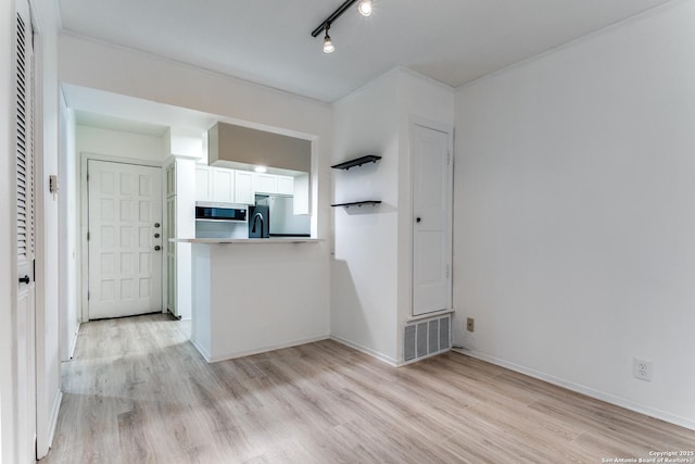 kitchen featuring light wood-style flooring, stainless steel appliances, visible vents, baseboards, and white cabinets