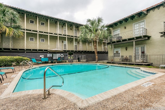 pool featuring french doors and fence