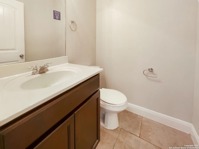 bathroom featuring toilet, tile patterned flooring, baseboards, and vanity