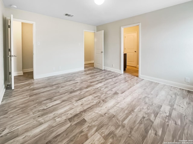 unfurnished bedroom featuring light wood-style flooring, visible vents, and baseboards