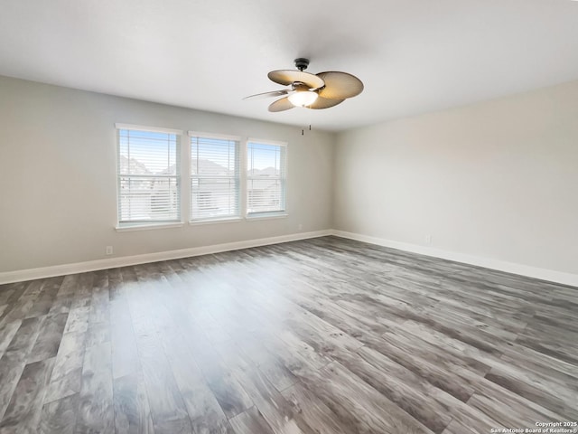 unfurnished room with a ceiling fan, baseboards, and wood finished floors