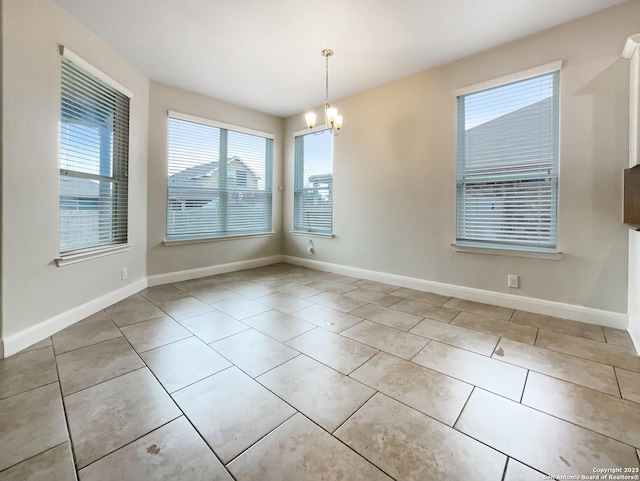 spare room featuring a chandelier, baseboards, and tile patterned floors