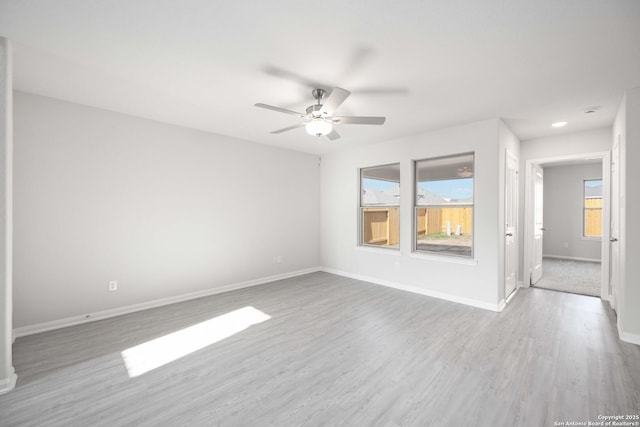 spare room featuring ceiling fan, baseboards, and wood finished floors