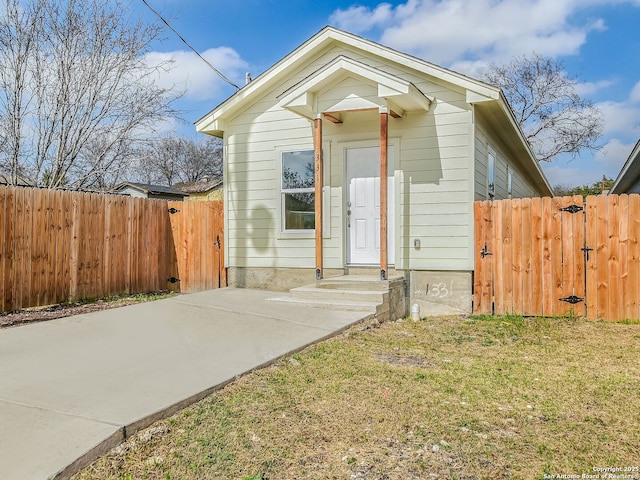 view of front of house featuring a front yard, fence, and a gate