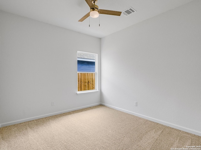 spare room featuring ceiling fan, carpet, visible vents, and baseboards