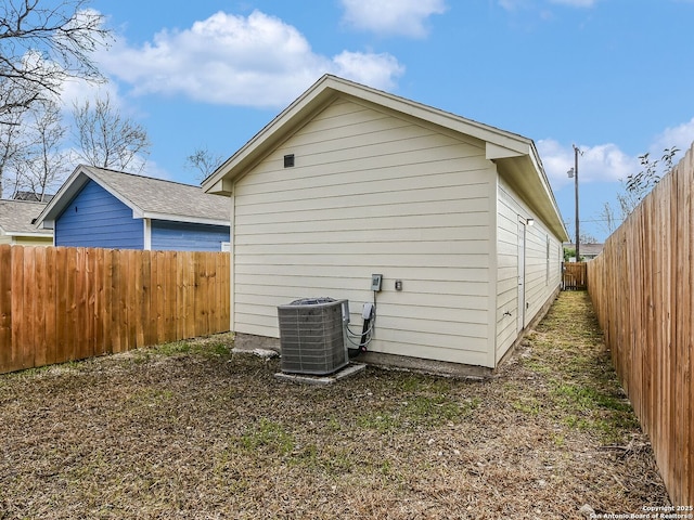 view of side of property with a fenced backyard and central AC unit