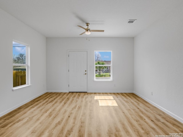 interior space featuring visible vents, baseboards, ceiling fan, and wood finished floors