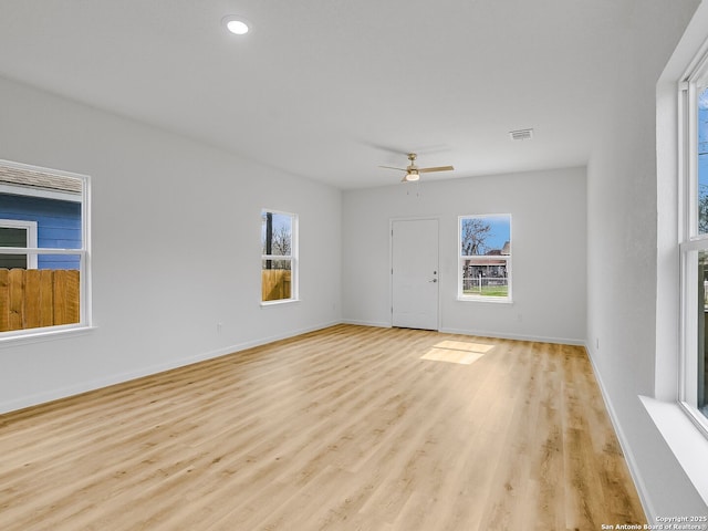 unfurnished living room with ceiling fan, light wood-style flooring, and baseboards