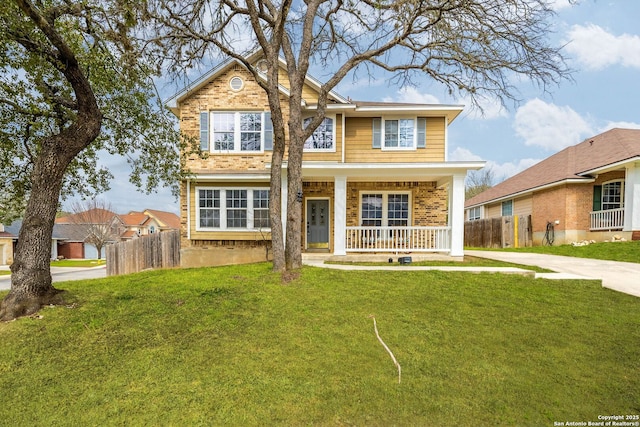 view of front of home featuring a front yard, fence, a porch, and brick siding