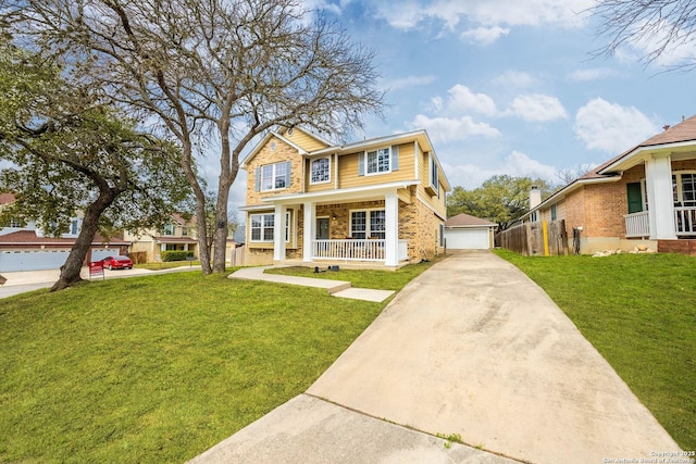 view of front of property with a porch, brick siding, a detached garage, and a front lawn