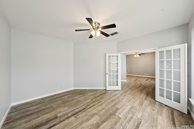 spare room featuring french doors, wood finished floors, visible vents, and baseboards