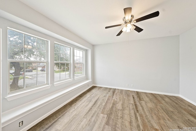 unfurnished room with ceiling fan, baseboards, and wood finished floors