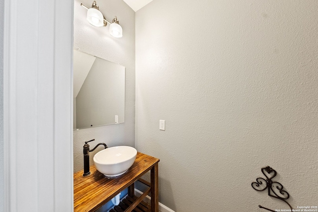 bathroom with a textured wall and a sink