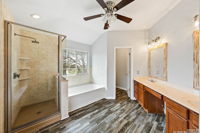 full bath with wood finished floors, vaulted ceiling, a bath, double vanity, and a stall shower