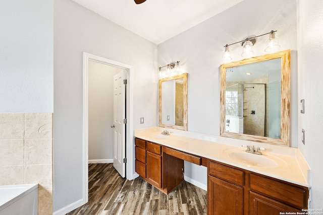 full bath featuring a sink, wood finished floors, a shower stall, a bath, and double vanity