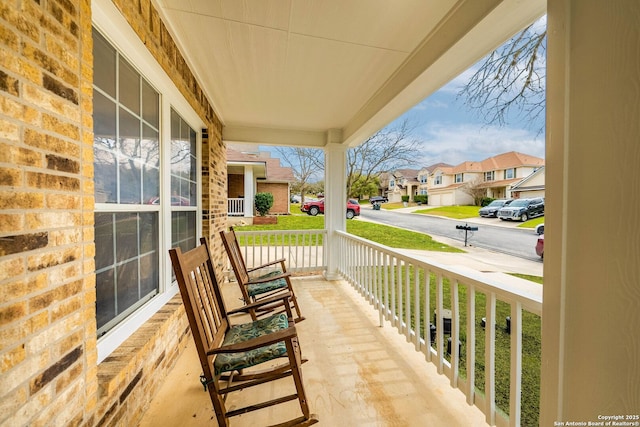 balcony featuring covered porch and a residential view