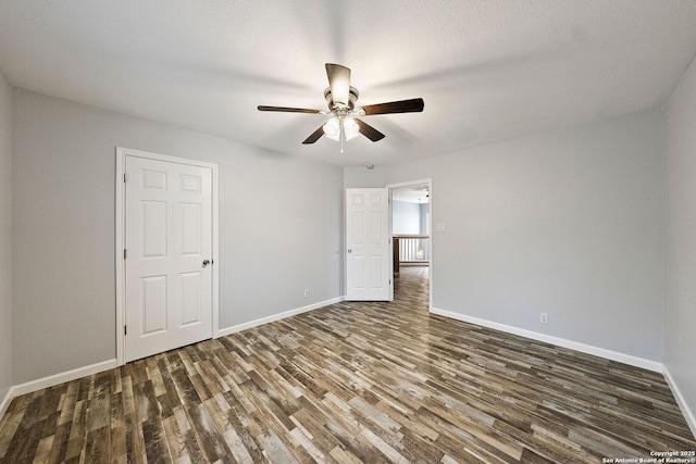 spare room with ceiling fan, wood finished floors, and baseboards