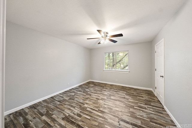 spare room with ceiling fan, baseboards, dark wood finished floors, and a textured ceiling