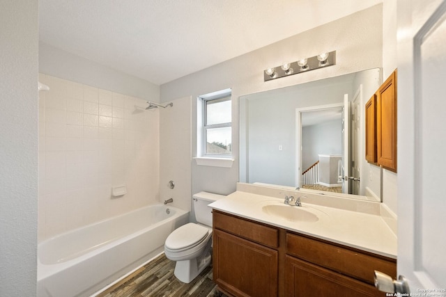 full bathroom with toilet, washtub / shower combination, wood finished floors, and vanity