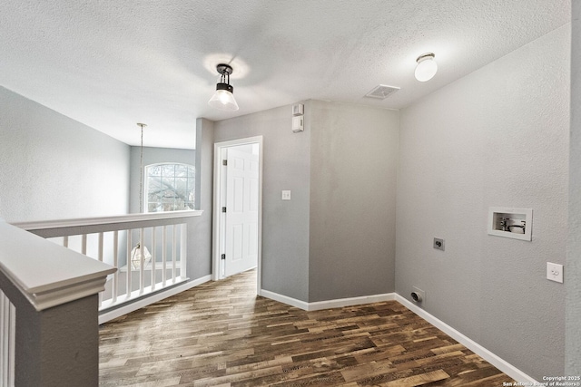 laundry room with washer hookup, electric dryer hookup, a textured ceiling, and wood finished floors